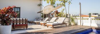 Piscine sur le toit avec vue sur la skyline, chaises longues.